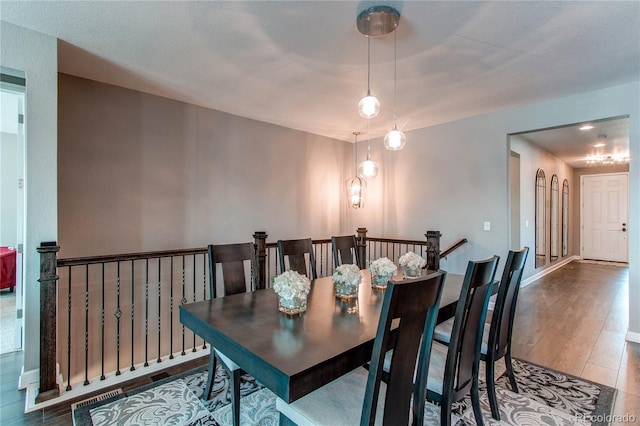 dining space with baseboards and wood finished floors