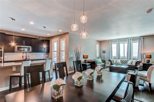 dining room featuring dark wood-type flooring, recessed lighting, a textured ceiling, and baseboards