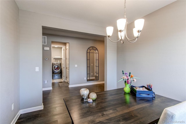 dining space featuring a chandelier, dark wood-style flooring, visible vents, baseboards, and washer / clothes dryer