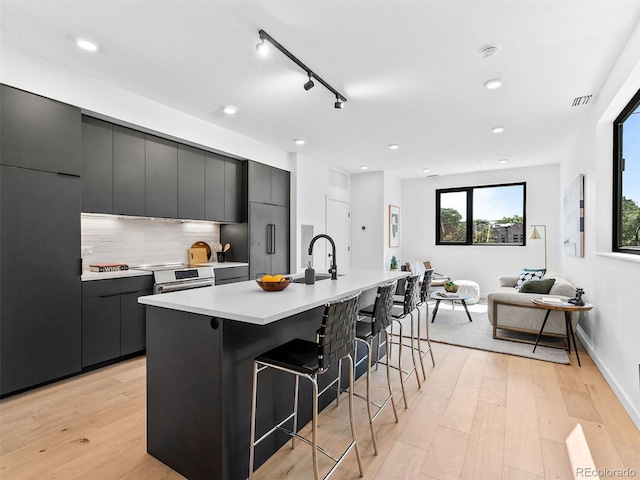 kitchen with modern cabinets, a breakfast bar, and light countertops