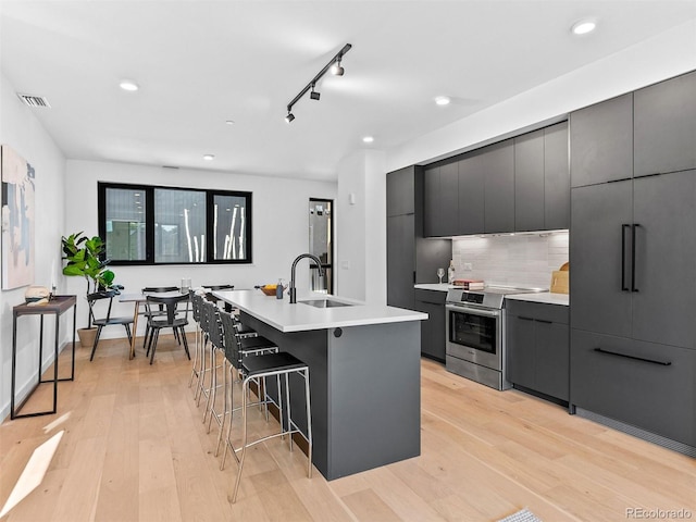 1601 Park Ave Unit 212, Denver, CO 80218 - kitchen featuring visible vents, a sink, stainless steel electric range, and modern cabinets