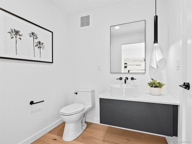1601 Park Ave Unit 212, Denver, CO 80218 - bathroom with baseboards, visible vents, toilet, wood finished floors, and vanity