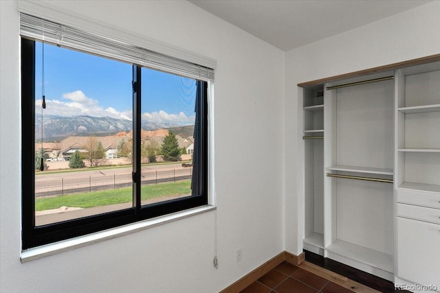 2979 Mesa Rd Unit D, Colorado Springs, CO 80904 - unfurnished bedroom featuring a closet, dark tile patterned floors, multiple windows, and baseboards