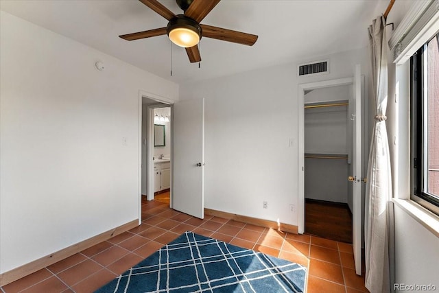 2979 Mesa Rd Unit D, Colorado Springs, CO 80904 - unfurnished bedroom with tile patterned flooring, baseboards, a closet, a ceiling fan, and a spacious closet