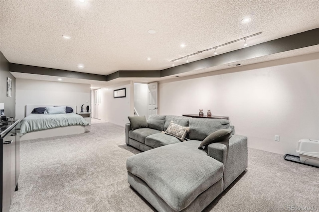 bedroom with rail lighting, carpet, and a textured ceiling