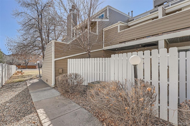 view of side of property with fence and a chimney