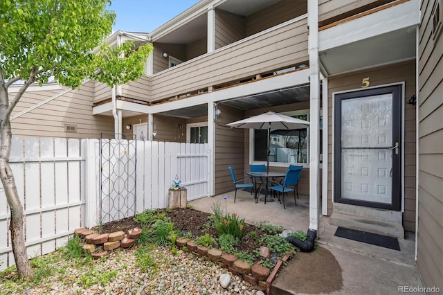 view of patio with fence, a balcony, and entry steps