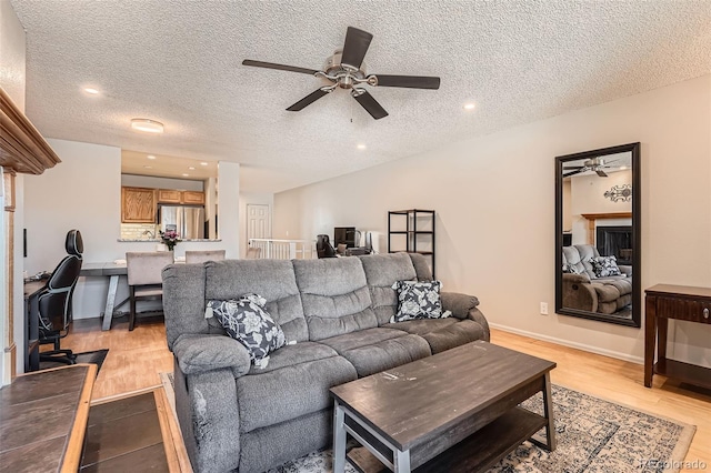 living room with ceiling fan and a textured ceiling