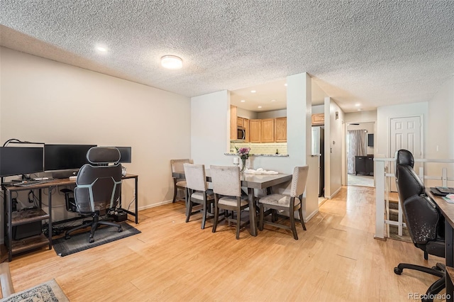 office area featuring a textured ceiling, baseboards, recessed lighting, and light wood-style flooring