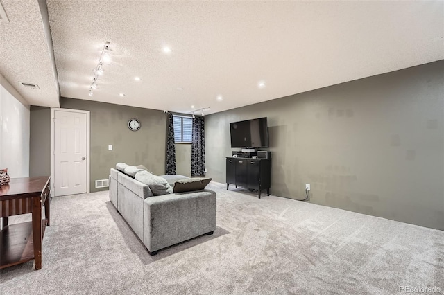 living room featuring recessed lighting, a textured ceiling, visible vents, and light carpet