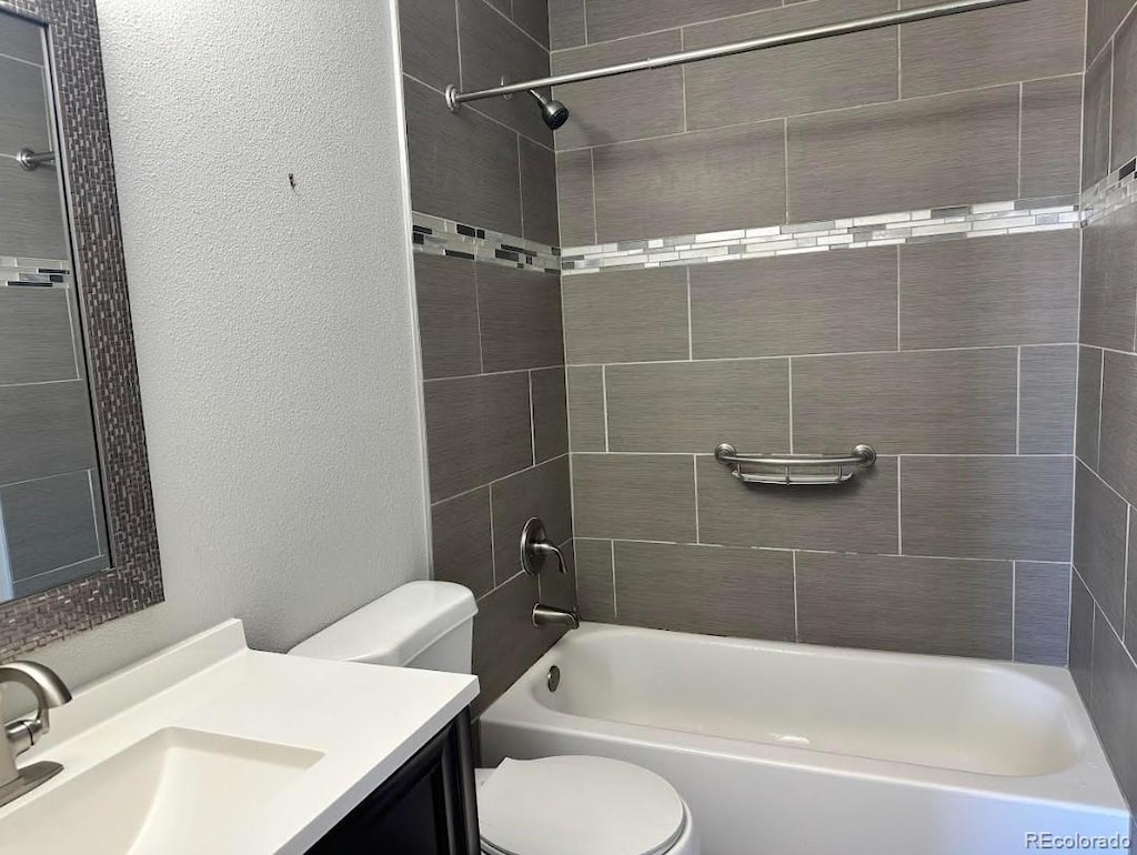 full bathroom with shower / bathtub combination, a textured wall, vanity, and toilet