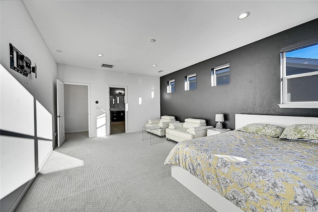 carpeted bedroom featuring recessed lighting, visible vents, and a textured wall