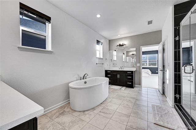 full bath featuring vanity, visible vents, baseboards, a soaking tub, and a stall shower