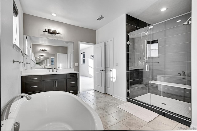 full bathroom featuring a stall shower, visible vents, a soaking tub, tile patterned flooring, and vanity