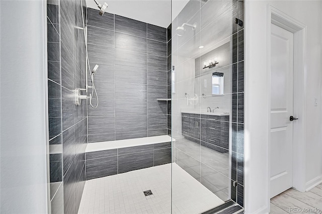 bathroom featuring a tile shower and vanity