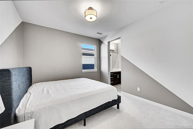 bedroom with baseboards, visible vents, ensuite bathroom, and light colored carpet