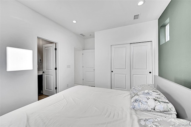 bedroom with a closet, visible vents, and recessed lighting