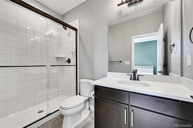 ensuite bathroom with tile patterned flooring, toilet, vanity, a shower stall, and ensuite bath