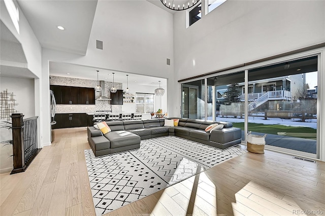 living area featuring an inviting chandelier, visible vents, and light wood-style floors