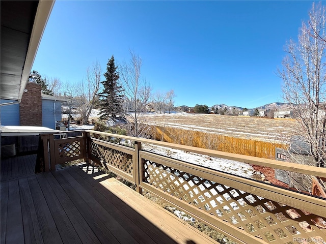 snow covered deck with a mountain view