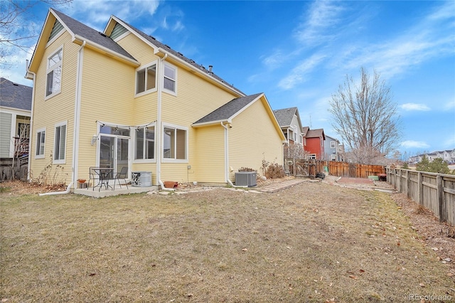 back of property featuring a patio, a yard, central AC, and a fenced backyard