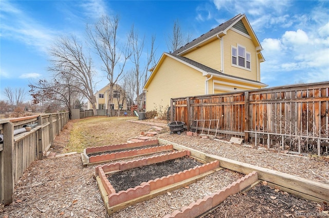 view of yard featuring a fenced backyard and a garden