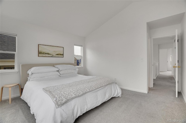 carpeted bedroom with vaulted ceiling and baseboards