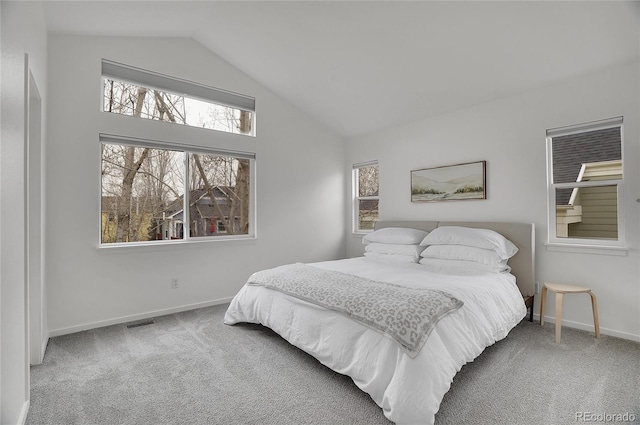 bedroom with carpet floors, visible vents, baseboards, and vaulted ceiling