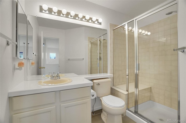 bathroom featuring vanity, a shower stall, and toilet