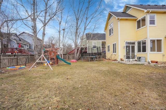 view of yard featuring a trampoline, a playground, a patio, central air condition unit, and a fenced backyard