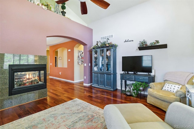 15501 E 112th Ave Unit 20C, Commerce City, CO 80022 - living area with high vaulted ceiling, wood finished floors, a ceiling fan, arched walkways, and a tile fireplace