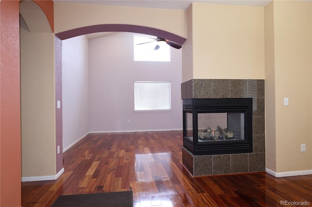 15501 E 112th Ave Unit 20C, Commerce City, CO 80022 - unfurnished living room with wood finished floors, arched walkways, a fireplace, a ceiling fan, and baseboards
