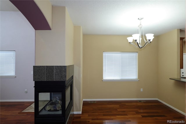 15501 E 112th Ave Unit 20C, Commerce City, CO 80022 - unfurnished living room with wood finished floors, a chandelier, a multi sided fireplace, and baseboards