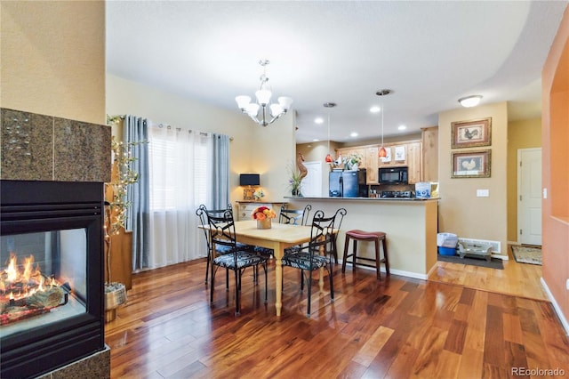 15501 E 112th Ave Unit 20C, Commerce City, CO 80022 - dining room featuring wood finished floors, a chandelier, a tile fireplace, and recessed lighting