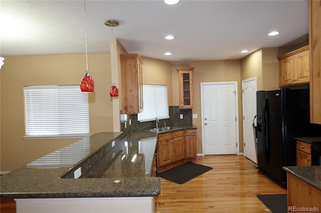 15501 E 112th Ave Unit 20C, Commerce City, CO 80022 - kitchen with black fridge with ice dispenser, a peninsula, a sink, light wood-type flooring, and backsplash