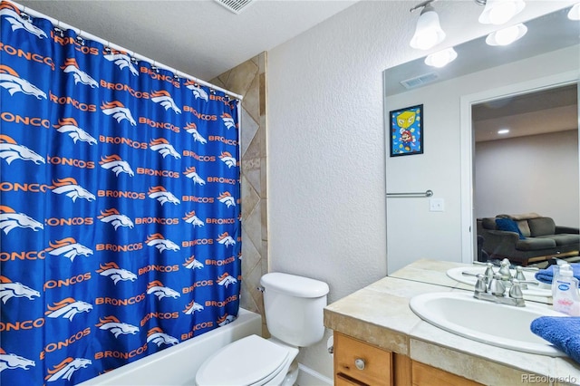 15501 E 112th Ave Unit 20C, Commerce City, CO 80022 - bathroom featuring vanity, toilet, a textured wall, and shower / bath combo with shower curtain