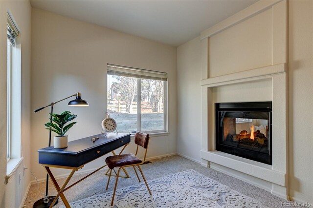 office space featuring a multi sided fireplace and light carpet