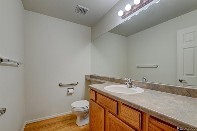 bathroom with vanity, wood-type flooring, and toilet