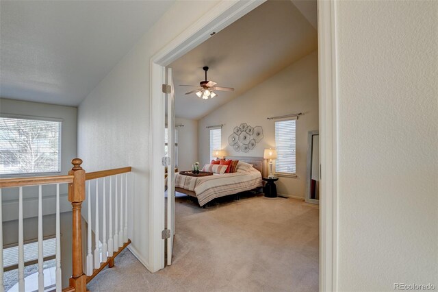 bedroom featuring multiple windows, ceiling fan, light carpet, and lofted ceiling