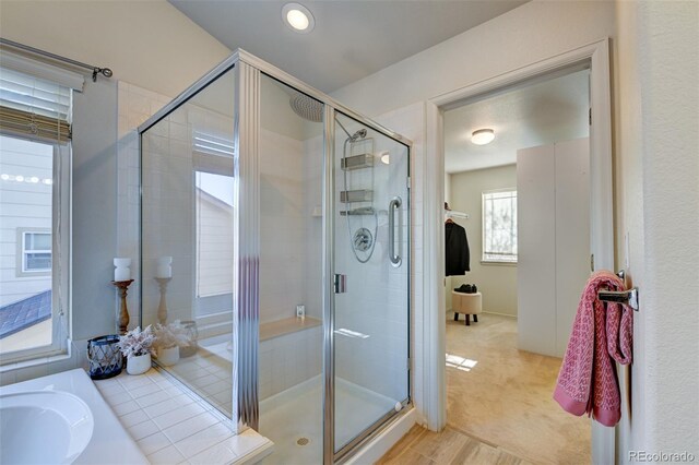 bathroom with sink, a shower with shower door, and hardwood / wood-style flooring