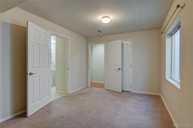 unfurnished bedroom featuring light carpet and a closet