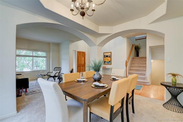 1460 Lily Lake Dr, Colorado Springs, CO 80921 - dining area featuring arched walkways, light carpet, stairs, and a chandelier