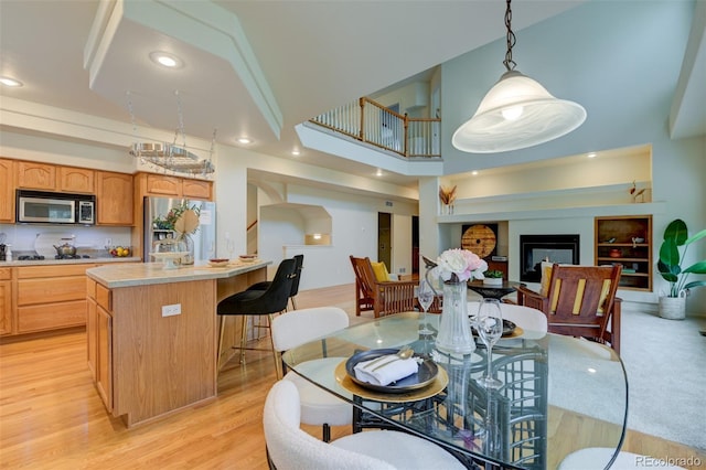 1460 Lily Lake Dr, Colorado Springs, CO 80921 - dining area featuring recessed lighting, a high ceiling, light wood-style flooring, and a fireplace