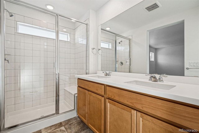 bathroom with vanity, a wealth of natural light, and a shower with shower door