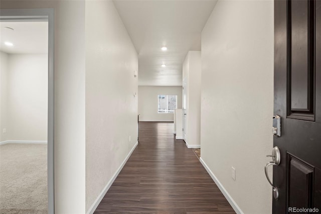 hallway featuring recessed lighting, dark wood finished floors, and baseboards