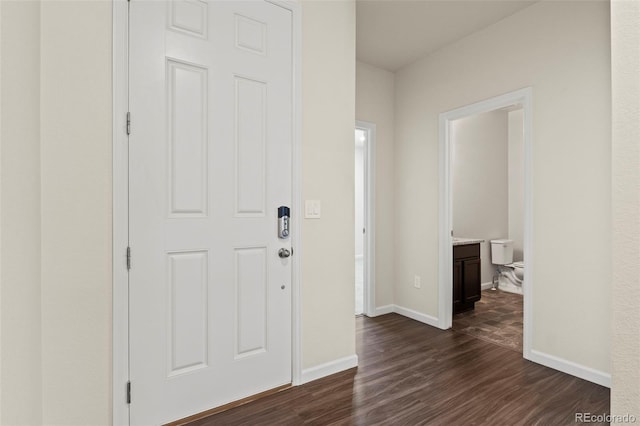 entryway with dark wood-style floors and baseboards