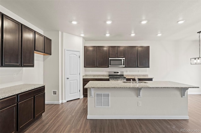 kitchen with dark wood-type flooring, a sink, visible vents, dark brown cabinets, and appliances with stainless steel finishes