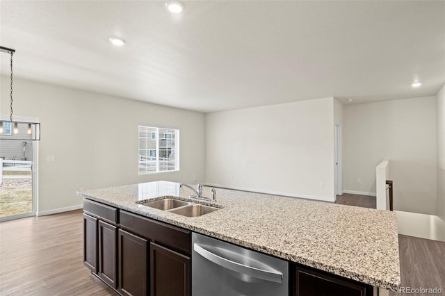 kitchen featuring light wood-style flooring, dark brown cabinetry, a sink, light stone countertops, and dishwasher