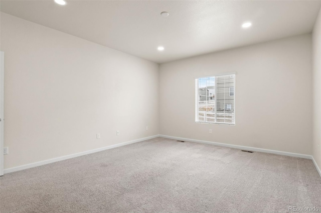 spare room featuring recessed lighting, carpet flooring, and baseboards