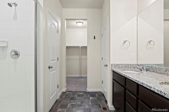 bathroom with stone finish flooring, a stall shower, a sink, and visible vents